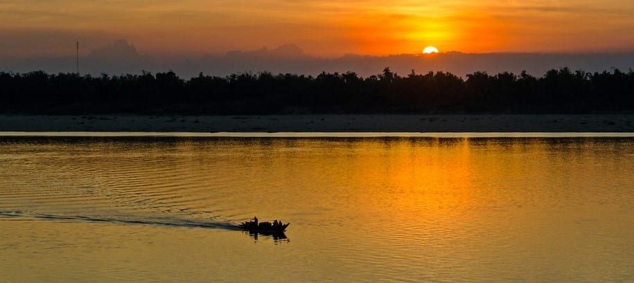 Au coucher du soleil, pêcheur en bateau sur le Mékong au large de Kratie