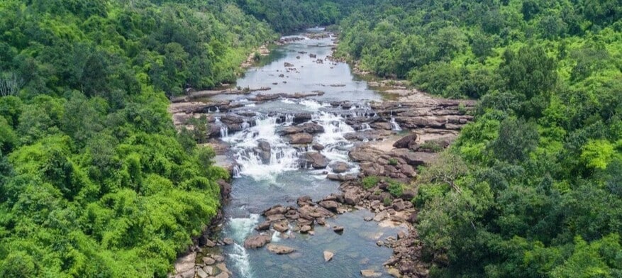 Vue aérienne sur une cascade et la rivière qui traverse la jungle dans la région des Cardamomes