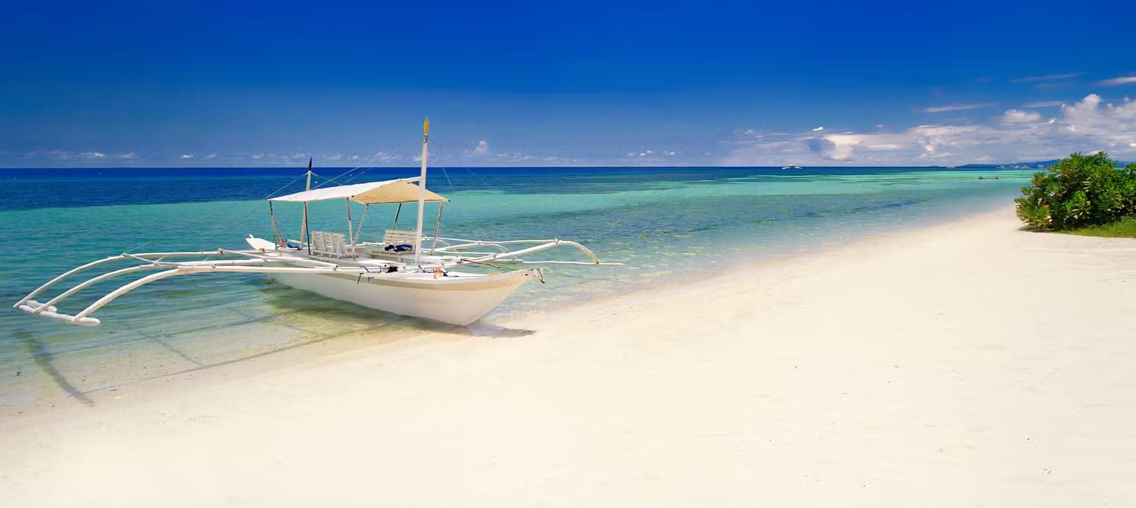 Banka typique des Philippines posée sur le sable blanc d'une plage paradisiaque de Bohol dans l'archipel des Visayas