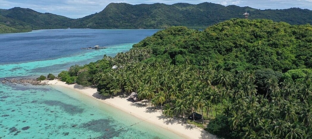 Plage de sable blanc qui borde le lagon de Flower Island au large de Palawan