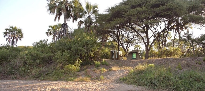 Tente safari sur les berges d'une rivière ensablée dans le parc de Ruaha